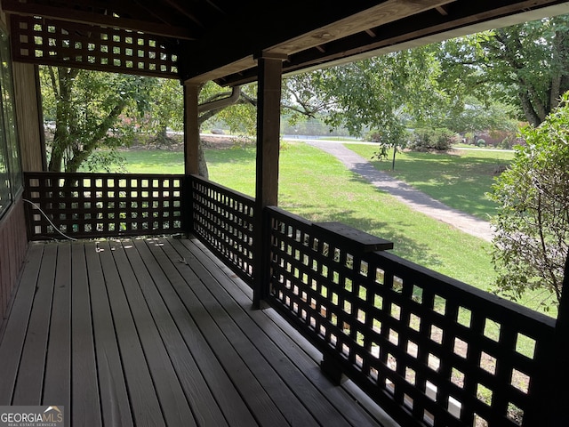 wooden terrace featuring a lawn