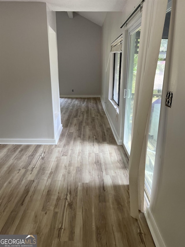 entrance foyer featuring baseboards, lofted ceiling, and wood finished floors