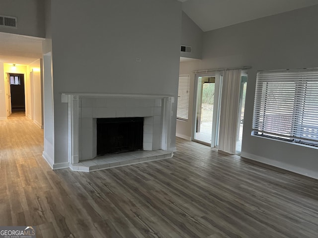 unfurnished living room with high vaulted ceiling, visible vents, and wood finished floors