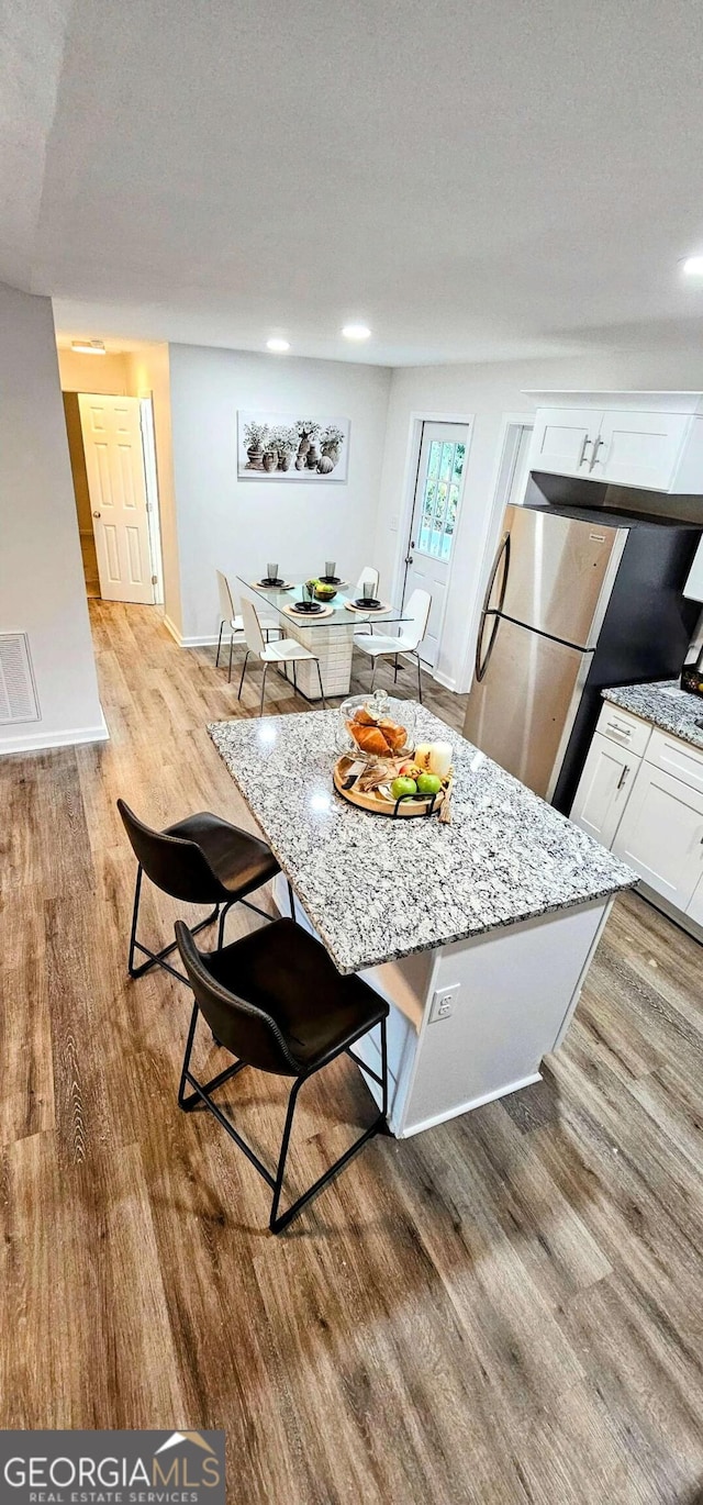 dining area featuring visible vents, a textured ceiling, baseboards, and light wood-type flooring
