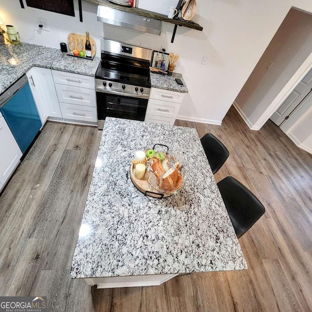 kitchen featuring white cabinets, dishwasher, light wood-type flooring, light stone counters, and stainless steel electric stove