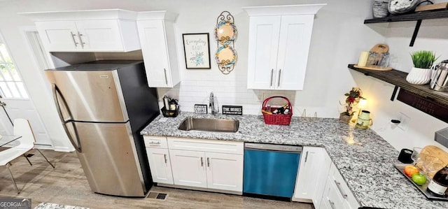 kitchen featuring tasteful backsplash, a sink, dishwashing machine, open shelves, and freestanding refrigerator