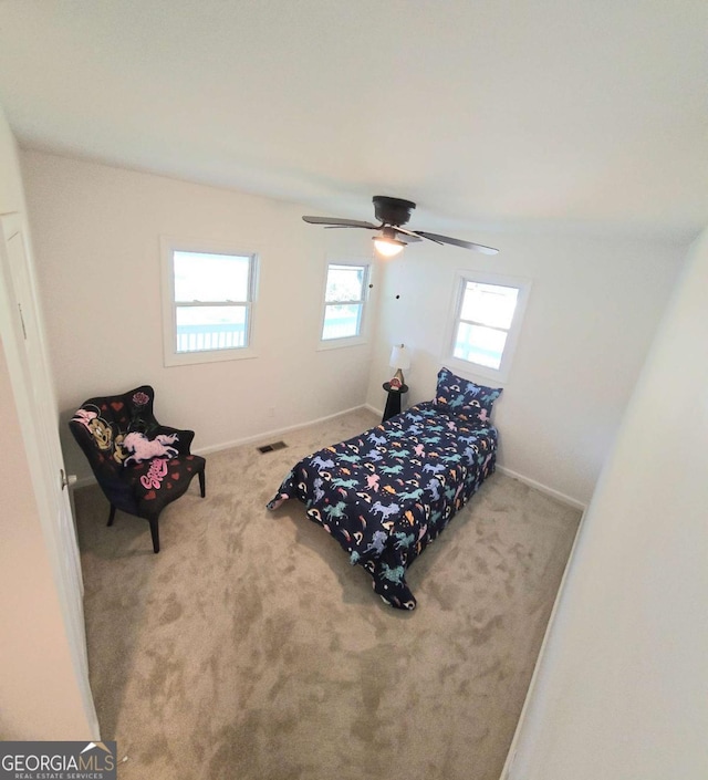 bedroom with baseboards, a ceiling fan, visible vents, and carpet