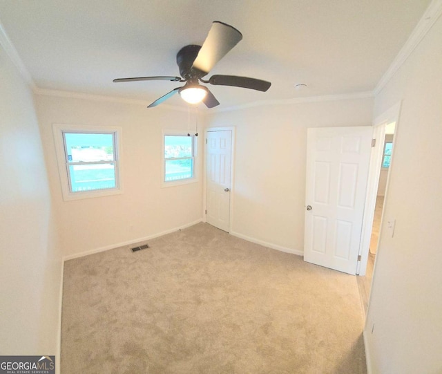 unfurnished bedroom featuring baseboards, carpet floors, visible vents, and crown molding