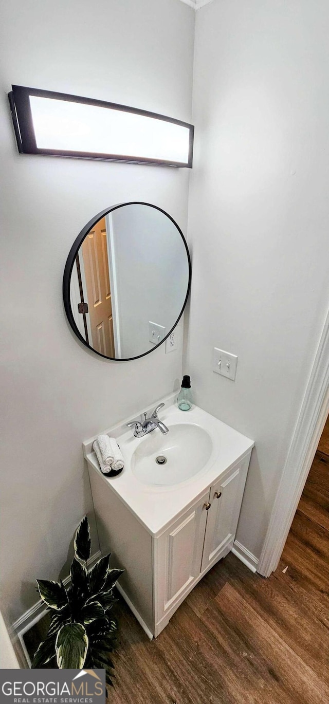 bathroom featuring baseboards, wood finished floors, and vanity