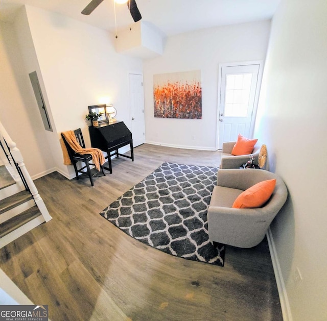 sitting room with baseboards, wood finished floors, and a ceiling fan