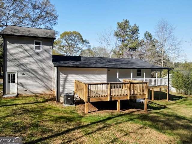 rear view of property with central air condition unit, a lawn, and a wooden deck