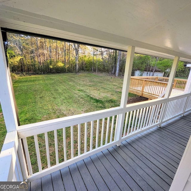 deck featuring a lawn and a water view