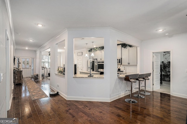 kitchen with crown molding, baseboards, and dark wood-type flooring
