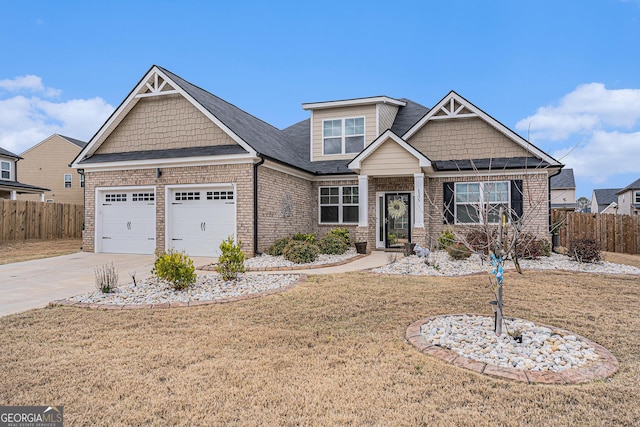 craftsman inspired home featuring an attached garage, fence, driveway, and a front yard