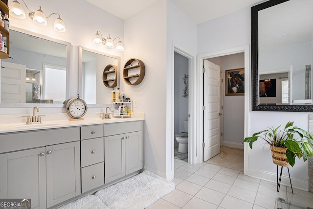 bathroom with a sink, baseboards, and toilet