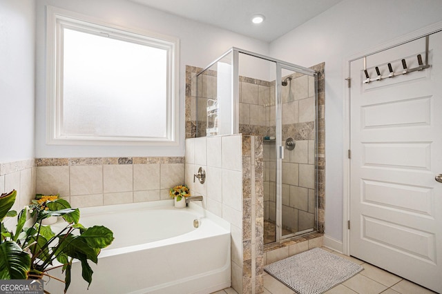 bathroom featuring tile patterned flooring, plenty of natural light, a shower stall, and a bath