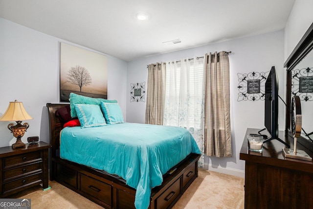 bedroom featuring baseboards, light carpet, and visible vents