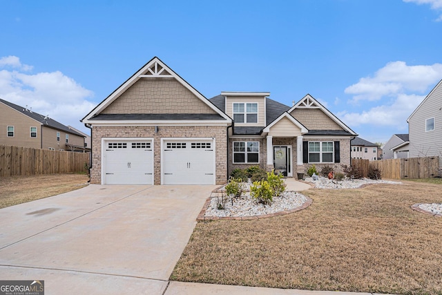 craftsman-style house with fence, a front lawn, driveway, and a garage