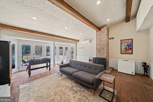 living room with french doors, beam ceiling, brick floors, an AC wall unit, and recessed lighting