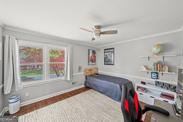 bedroom with wood finished floors, baseboards, crown molding, a ceiling fan, and a desk