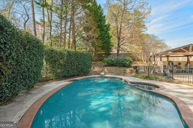 view of pool featuring a fenced backyard, a pool with connected hot tub, and a patio area