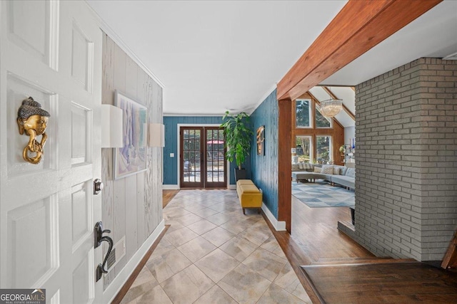 entryway featuring healthy amount of natural light, ornamental molding, french doors, brick wall, and wood walls