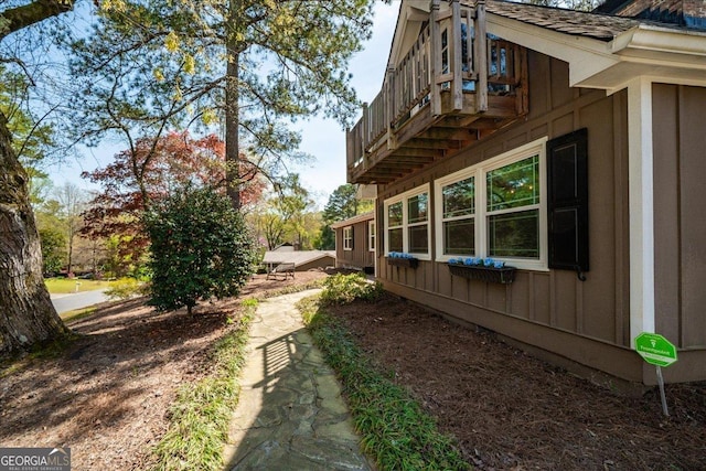 view of side of home with board and batten siding and a balcony