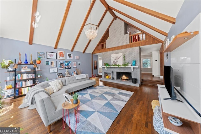 living area with high vaulted ceiling, wood finished floors, a fireplace, beam ceiling, and a chandelier