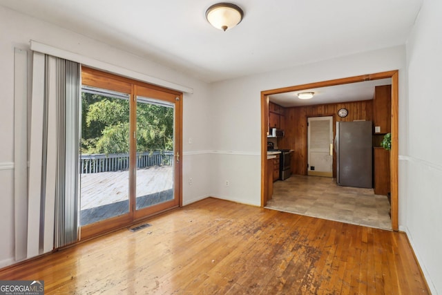 spare room featuring light wood-style flooring, baseboards, and visible vents