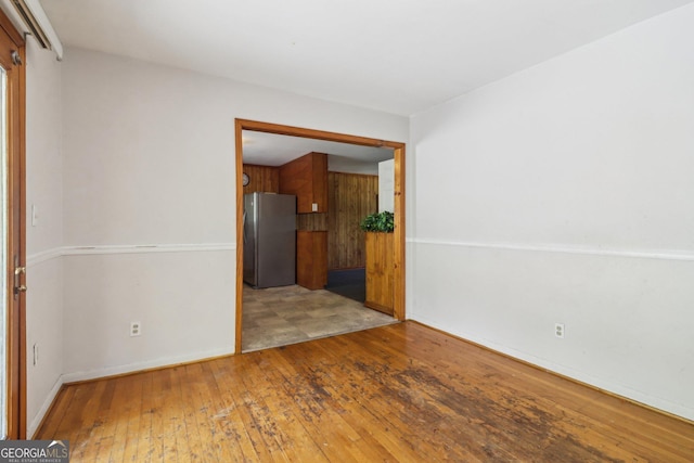 unfurnished room featuring baseboards and hardwood / wood-style floors