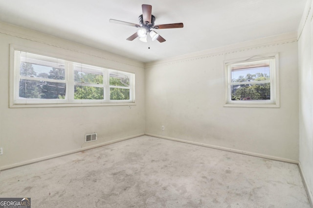 carpeted empty room featuring ceiling fan, baseboards, and visible vents