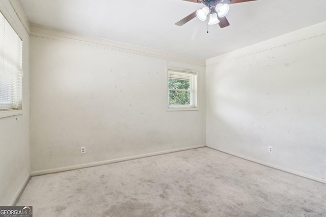 empty room featuring carpet floors, baseboards, and a ceiling fan