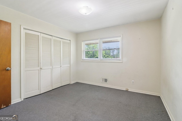 unfurnished bedroom featuring a closet, carpet flooring, baseboards, and visible vents