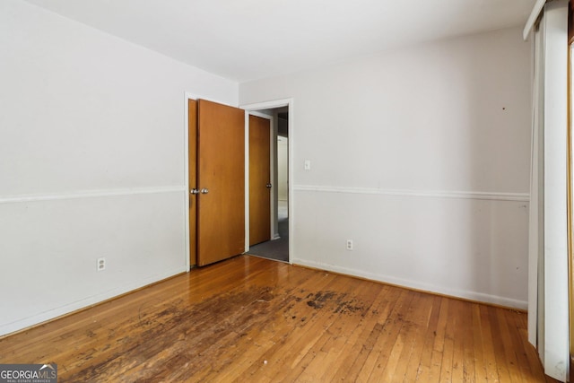 unfurnished room featuring baseboards and hardwood / wood-style flooring