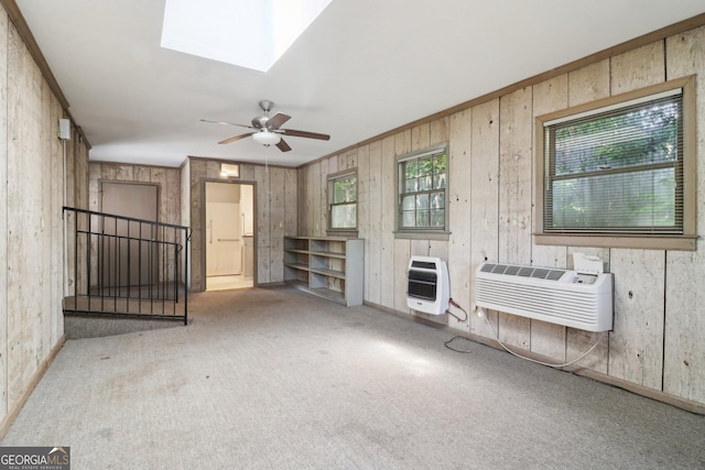 unfurnished living room featuring carpet flooring, a wealth of natural light, a wall mounted AC, and heating unit