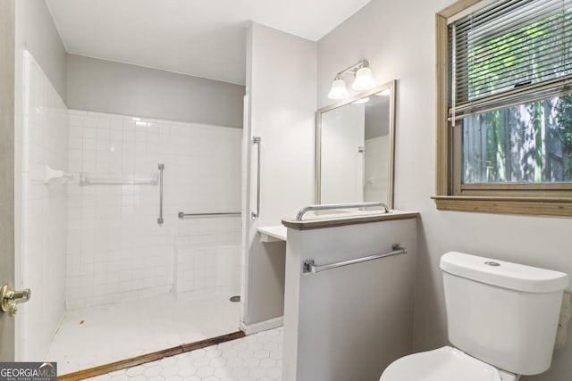 bathroom with tiled shower and toilet