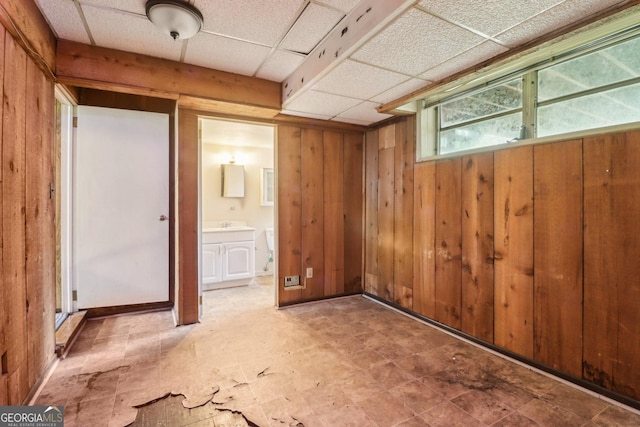 interior space featuring wood walls and a drop ceiling
