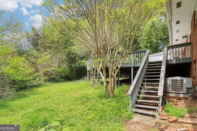 view of yard with cooling unit, a deck, and stairway