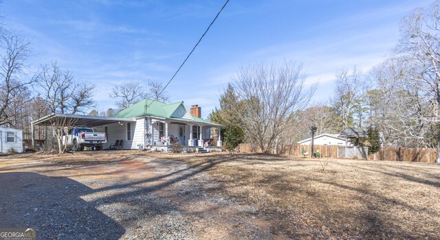 622 Cedartown Ave, Tallapoosa, GA 30176 - view of side of home featuring a porch, a carport, a chimney, and driveway