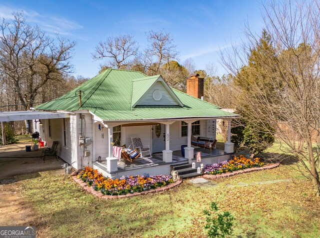 622 Cedartown Ave, Tallapoosa, GA 30176 - view of front of house featuring a porch, a chimney, metal roof, and a carport