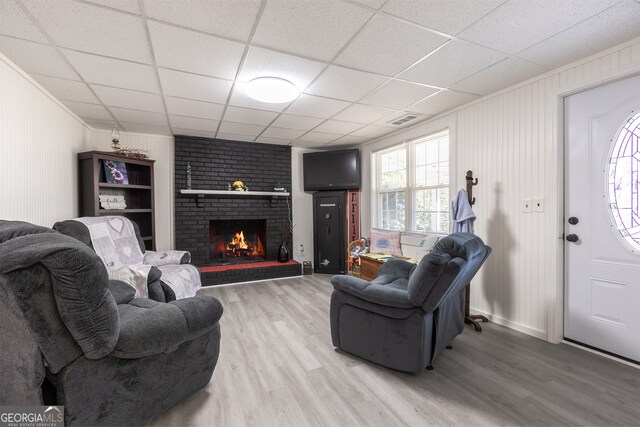 622 Cedartown Ave, Tallapoosa, GA 30176 - living area featuring wood finished floors, a brick fireplace, a paneled ceiling, and baseboards