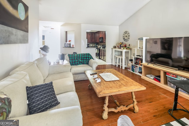 living room featuring vaulted ceiling and wood finished floors
