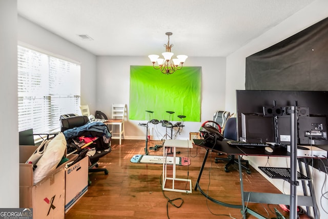 office space featuring wood finished floors, an inviting chandelier, and visible vents