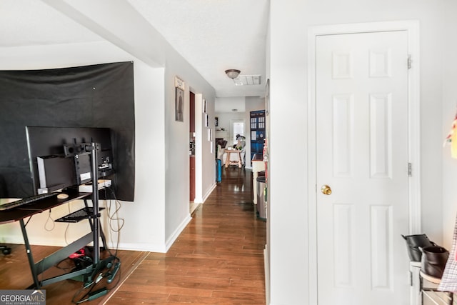 corridor with visible vents, baseboards, and wood finished floors