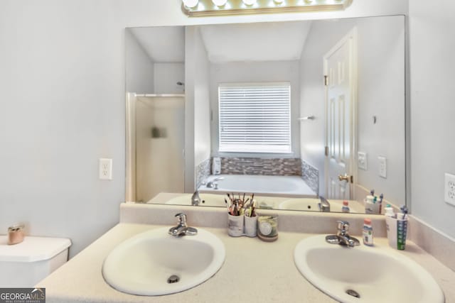 bathroom featuring double vanity, a sink, and a stall shower