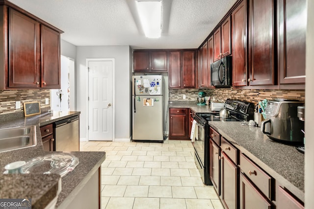 kitchen with tasteful backsplash, a textured ceiling, black appliances, light tile patterned flooring, and a sink