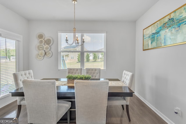 dining area featuring baseboards, an inviting chandelier, and dark wood-style floors