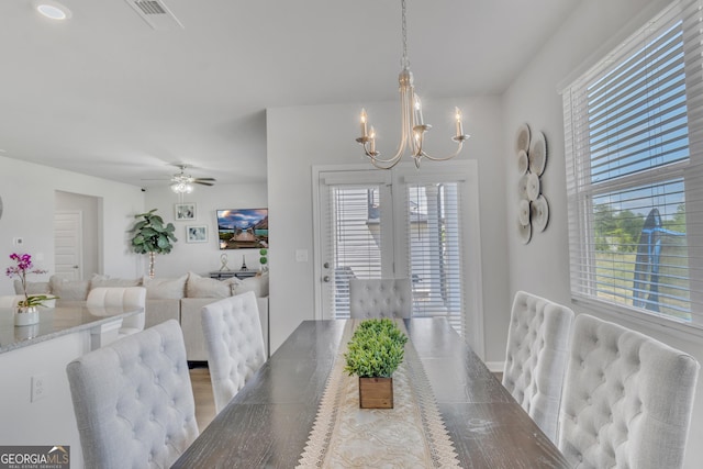 dining space featuring visible vents, plenty of natural light, and ceiling fan with notable chandelier