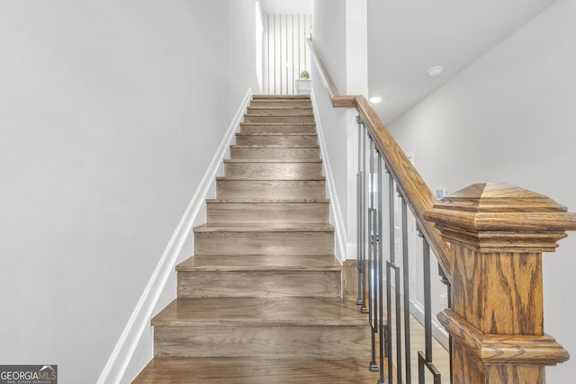 stairway featuring baseboards and wood finished floors
