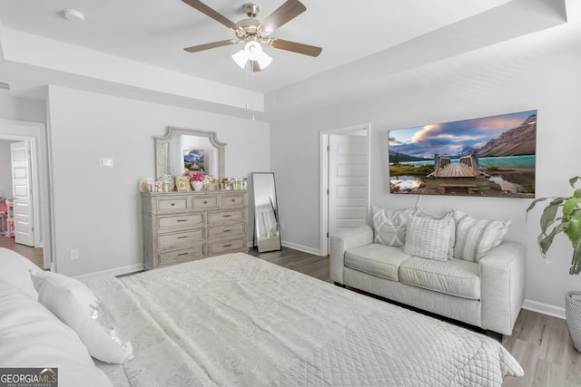 bedroom with a ceiling fan, baseboards, and wood finished floors