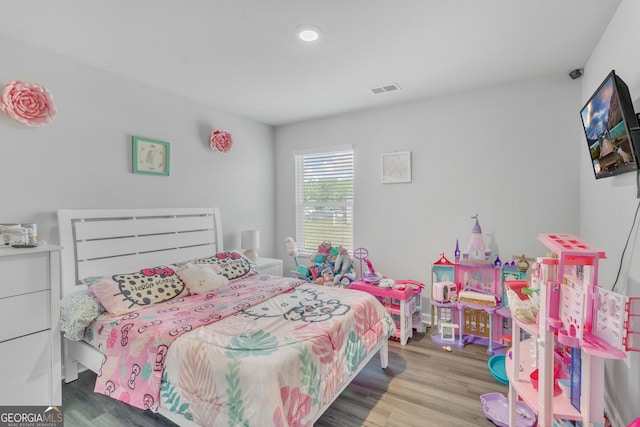 bedroom featuring visible vents and wood finished floors