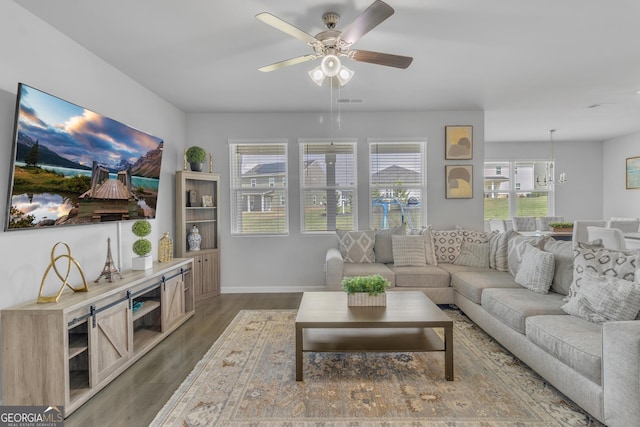 living area with baseboards, ceiling fan with notable chandelier, dark wood-style floors, and visible vents