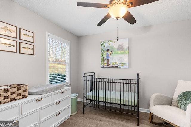 109 Shelton Ln, Eatonton, GA 31024 - bedroom featuring ceiling fan, baseboards, a nursery area, and wood finished floors