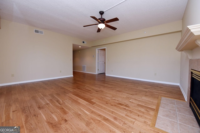 3112 Allison Ct, Young Harris, GA 30582 - unfurnished living room with light wood-type flooring, a ceiling fan, a fireplace, and visible vents